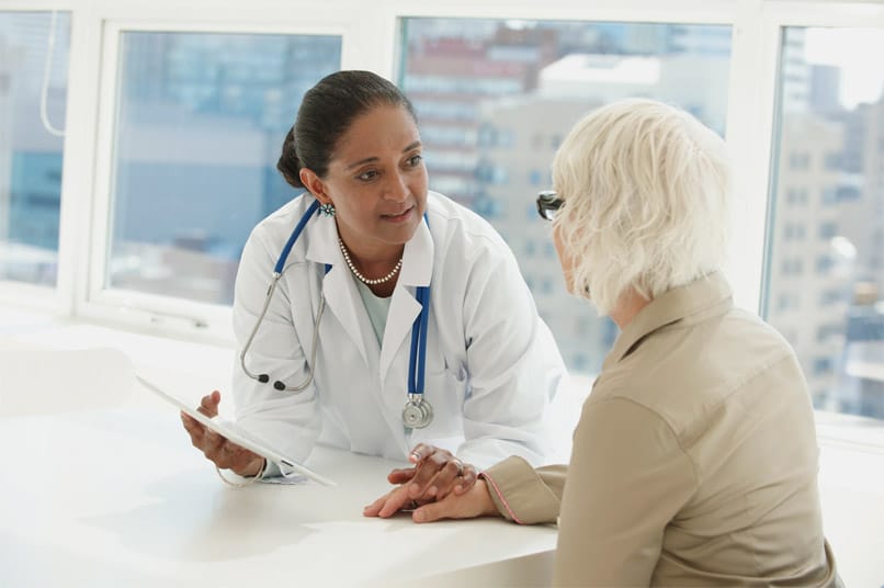 female doctor comforting older female patient